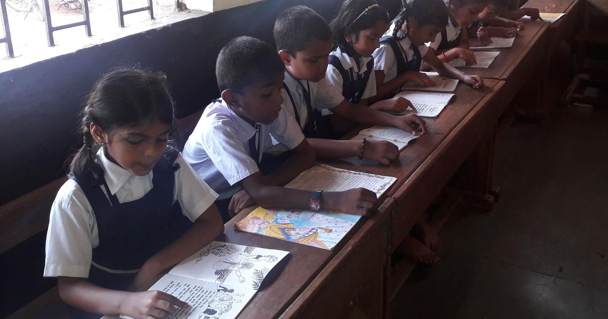 A group of children seated at their desks reading books